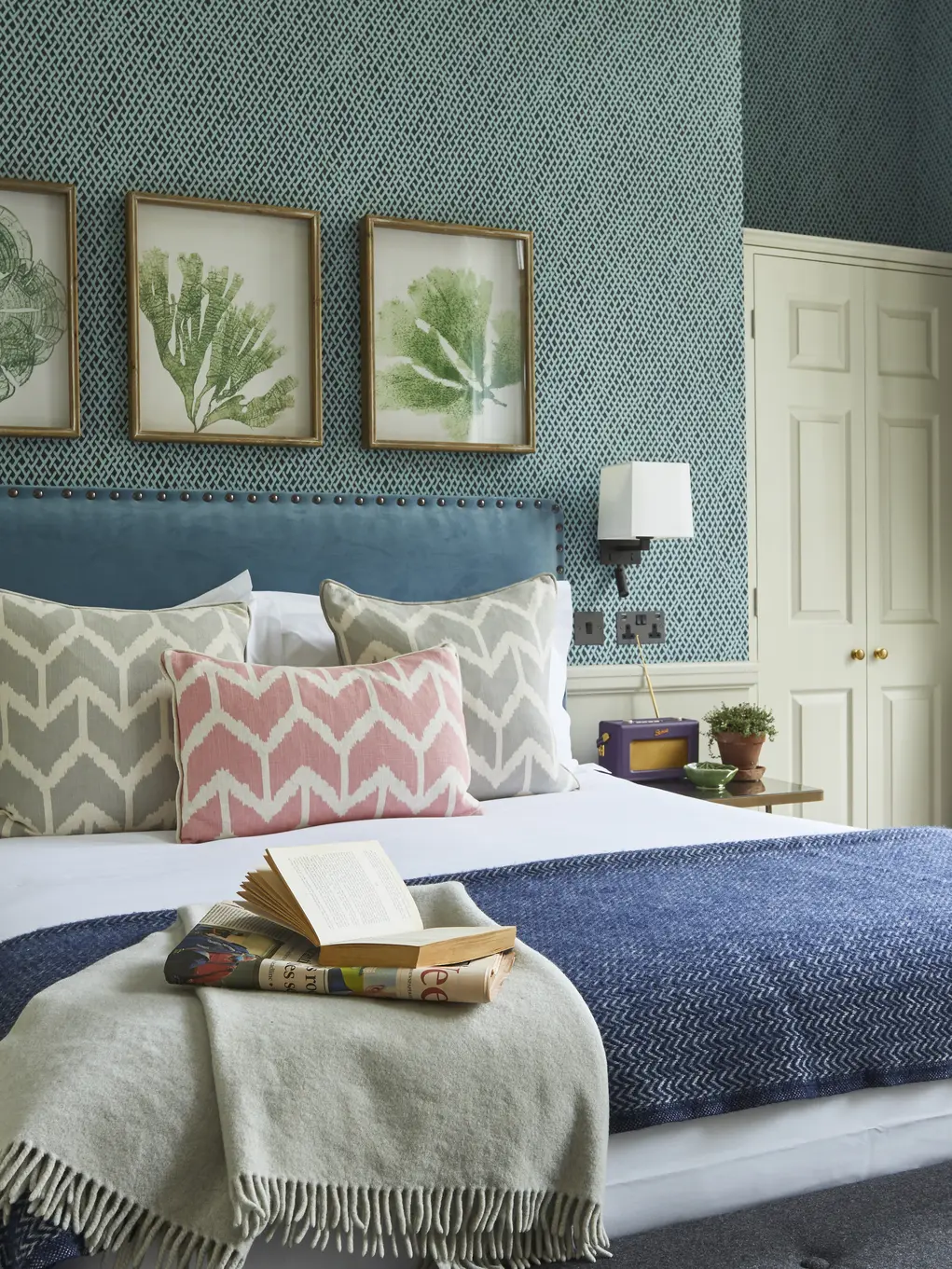 A hotel room with a bed and three botanical prints on the wall at the Lime Tree Hotel in Belgravia