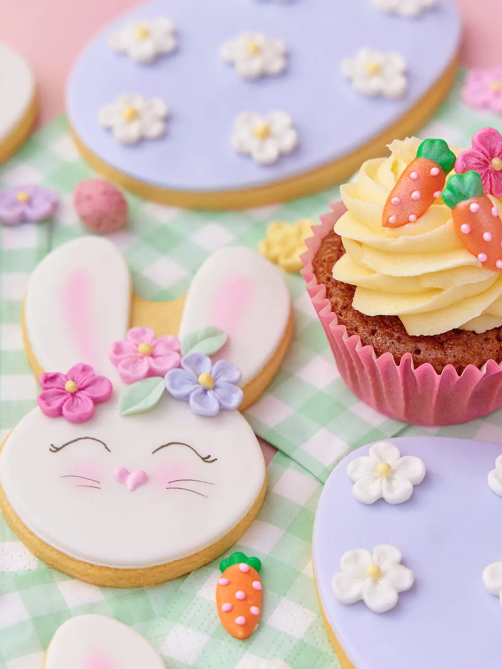Biscuits shaped like bunnies and a cupcake topped with sugar carrots