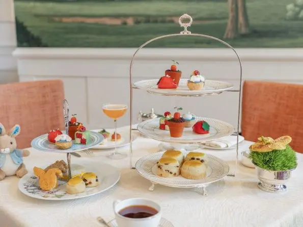 Afternoon tea with a Peter Rabbit toy and tiered plates filled with cakes